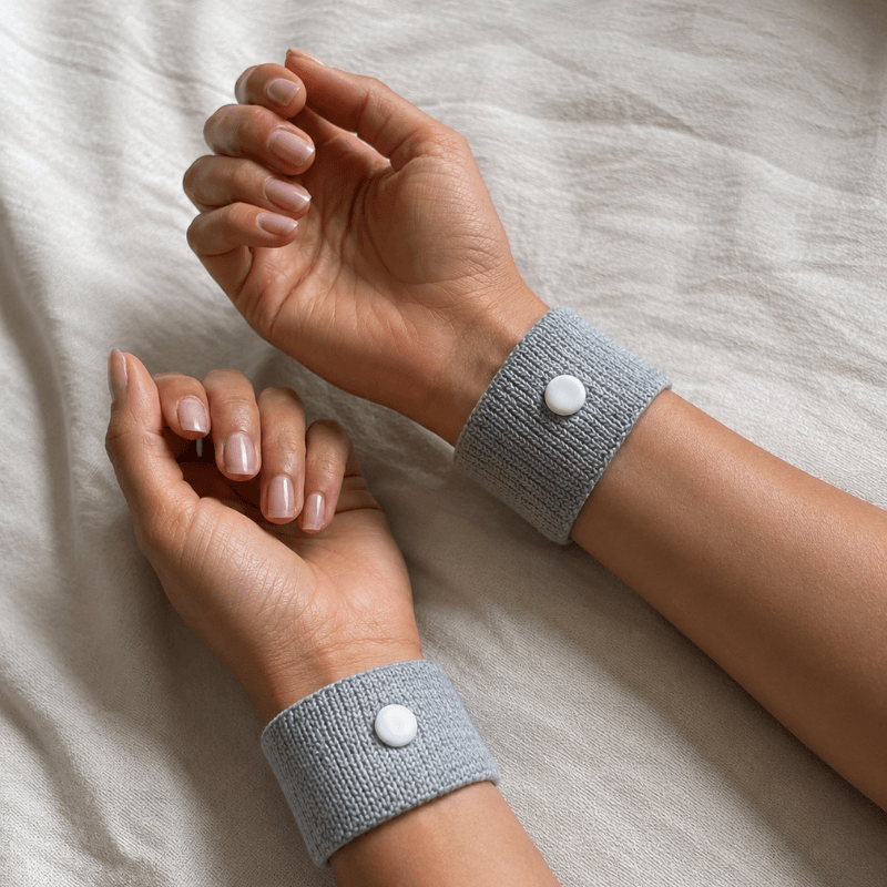 TAHVI Anchor wristbands worn on both wrists, resting on linen